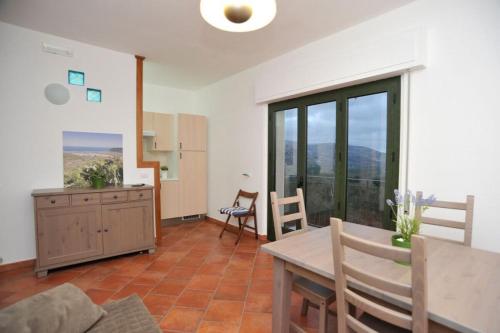 sala de estar con mesa y sillas y cocina en San Francesco Lodge en Mattinata