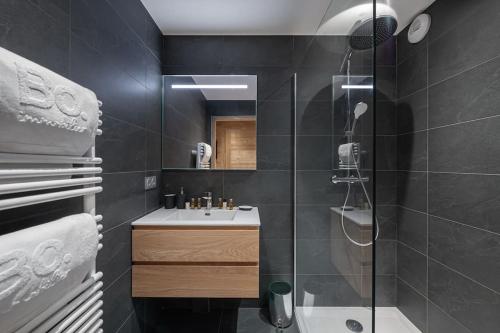 une salle de bain avec un lavabo et une douche en verre dans l'établissement La P'tite Grange - Apt 302 - BO Immobilier, à Châtel
