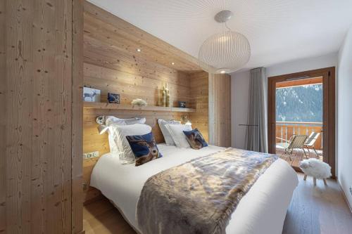 une chambre avec un grand lit avec un mur en bois dans l'établissement La P'tite Grange - Apt 302 - BO Immobilier, à Châtel