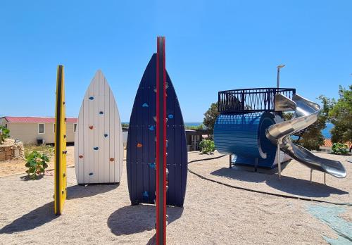 a group of surfboards and a slide on a playground at Mobilna kućica Val in Šimuni