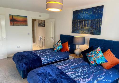 a living room with blue couches and a couch at Contemporary, Cosy & Homely 2 Bed Apartment with High-Speed WIFI, Terrace & Free Parking overlooking Stourbridge Common Park & Coldham's Brook in Cambridge