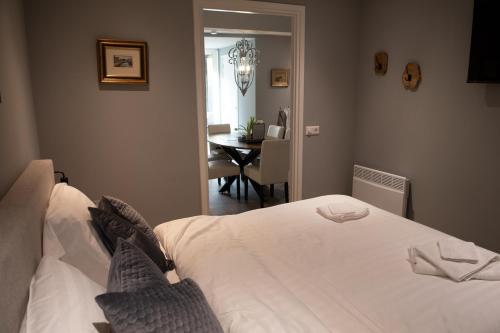 a bedroom with a white bed and a dining room at B en B Volendam in Volendam