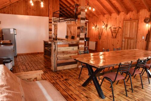 a dining room with a wooden table and chairs at Cabaña El Maqui in San Martín de los Andes