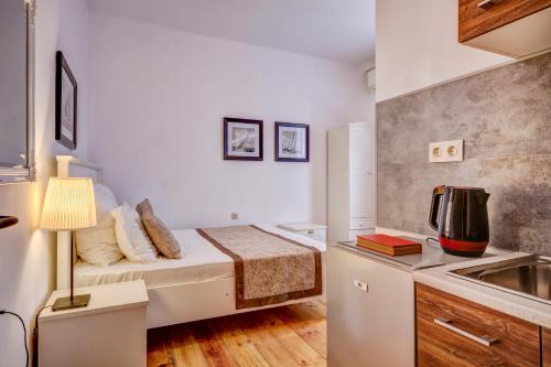 um pequeno quarto com uma cama e um lavatório em Just Studios em Varna City