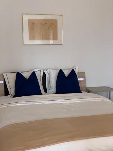 a large bed with blue and white pillows on it at City appartement in Lausanne