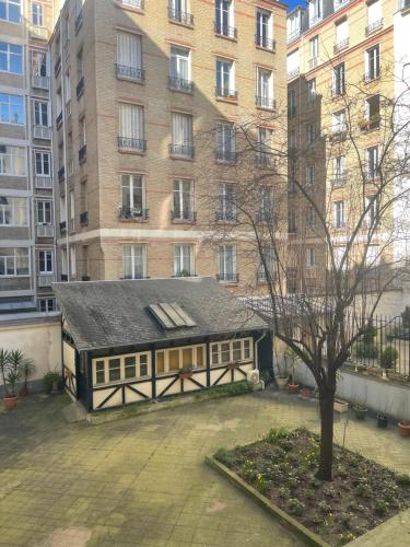 a small building in front of a tall building at Dream Dwell Paris-Cozy historic appartement near Exelmans in 16th District Paris in Paris