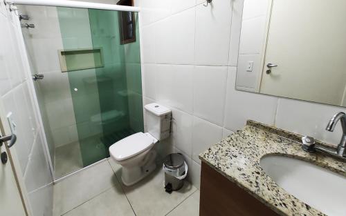 a bathroom with a toilet and a sink and a shower at Pousada Casa dos Sonhos in Campos do Jordão
