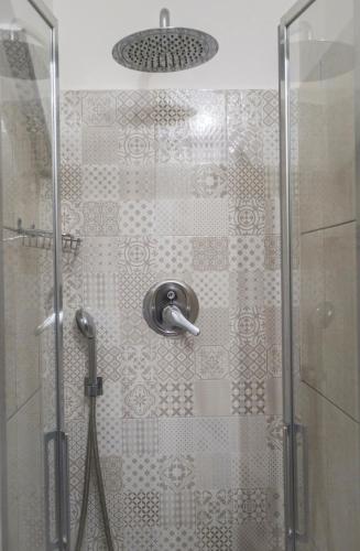 a shower stall with a glass door with a shower head at Agriturismo Bellofatto in Torella deʼ Lombardi