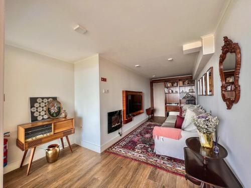 a living room with a white couch and a tv at Casas Dona Matilde in Torre de Moncorvo