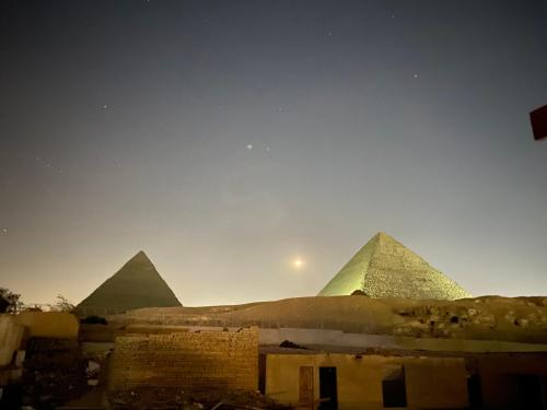 a view of the pyramids of giza at sunset at Pyramids Lounge Guest House in Cairo