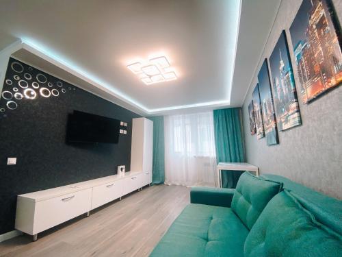 ein Wohnzimmer mit einem grünen Sofa und einem Flachbild-TV in der Unterkunft Best location in City center in Chişinău