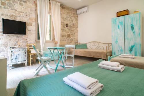 uma sala de estar com uma cama e uma mesa com toalhas em Rooms and Apartments Djanovic em Split