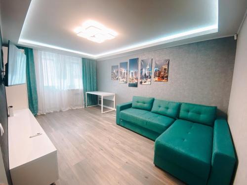 ein Wohnzimmer mit einer grünen Couch und einem Tisch in der Unterkunft Best location in City center in Chişinău