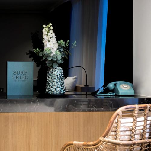 a vase of flowers on a counter with a phone at Hotel Nelson in Knokke-Heist