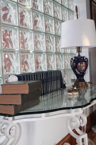a glass table with a lamp and books on it at Maison Sherman's house in Scotstown