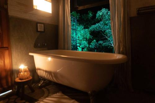 y baño con bañera y ventana. en Segredo dos Pireneus en Pirenópolis