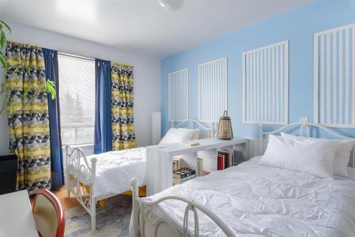 a blue bedroom with two beds and a desk at Maison Sherman's house in Scotstown