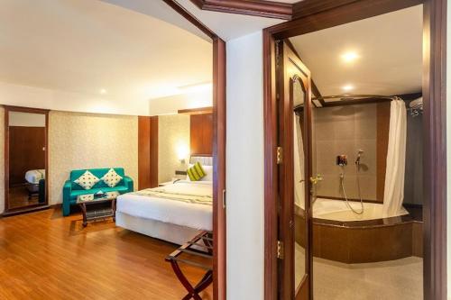 a bedroom with a bed and a bathroom with a shower at Residency Tower in Trivandrum