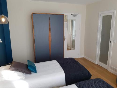 a bedroom with a large white bed with blue accents at Les Chants d'Ailes - Hôtel Face Mer in La Turballe