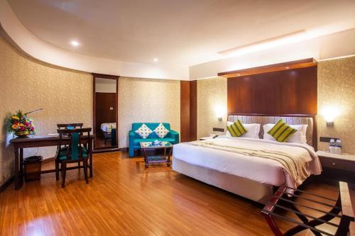 ein Schlafzimmer mit einem Bett und einem Schreibtisch in einem Zimmer in der Unterkunft Residency Tower in Thiruvananthapuram