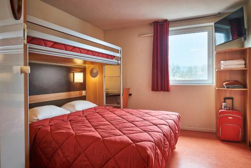 a bedroom with a bunk bed with a red bedspread at Premiere Classe Le Mans Ouest Universite in Le Mans