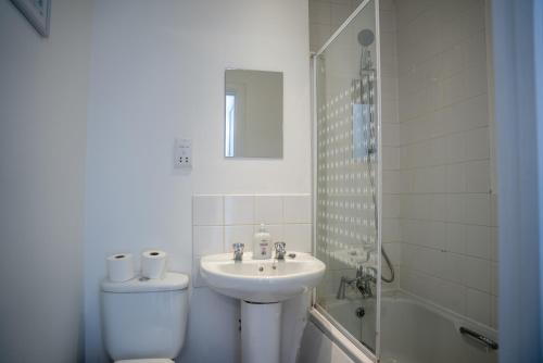 een badkamer met een wastafel, een toilet en een douche bij Comfortable 4 Bedroom Home in Milton Keynes by HP Accommodation with Free Parking, WiFi & Sky TV in Milton Keynes
