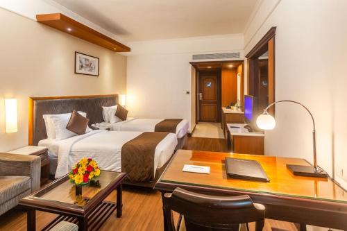 a hotel room with a bed and a desk at Residency Tower in Trivandrum
