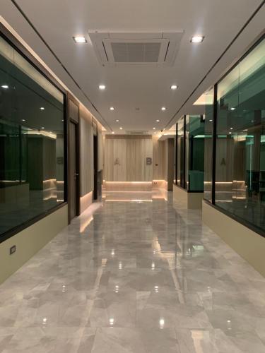 an empty hallway in a building with glass walls at Thana Wisut Hotel - SHA Plus in Bangkok