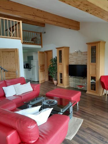 sala de estar con sofá rojo y mesa en Apartment mit Terrasse und Garten, en Saalfelden am Steinernen Meer