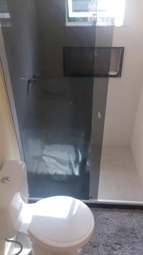a bathroom with a white toilet and a shower at Casa Griebeler 01 in Rio de Janeiro