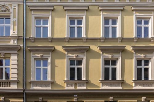 una fila de ventanas en un edificio amarillo en Felicjanek 15 en Cracovia
