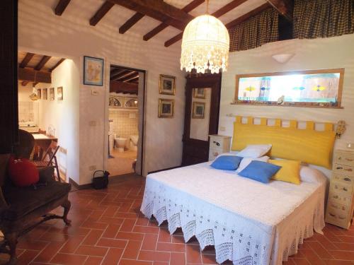 a bedroom with a bed with blue and yellow pillows at Pian De' Somari in Pitigliano