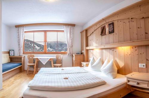 1 dormitorio con cama, mesa y ventana en Wiesenhof, en Kaunerberg