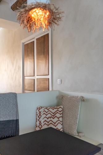 een kamer met een bank, een raam en een kroonluchter bij Hostal Aljibe in Archidona