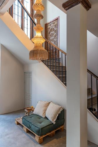 a living room with a green couch and stairs at Hostal Aljibe in Archidona