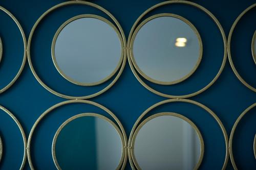 a wall with round mirrors on a blue wall at Les Chants d'Ailes - Hôtel Face Mer in La Turballe