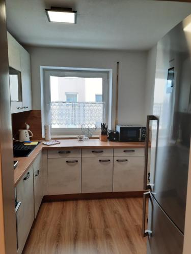 a kitchen with a refrigerator and a window in it at Moderne 3Zimmer Wohnung, in Königsbrunn bei Augsburg in Königsbrunn