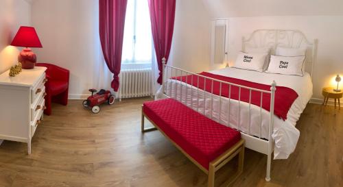 - une chambre avec un lit blanc et un banc rouge dans l'établissement CLOS DE LA BRIQUETERIE, à Noyers-sur-Cher