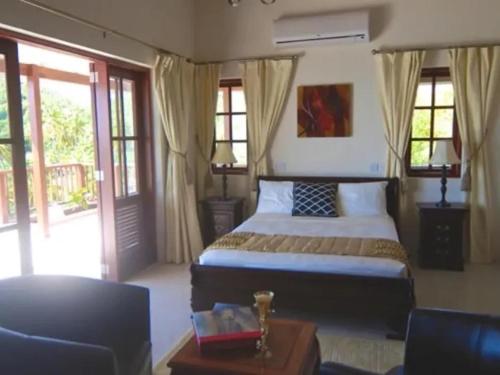 a bedroom with a bed and a table and a couch at IJEOMA HOUSE in Bequia