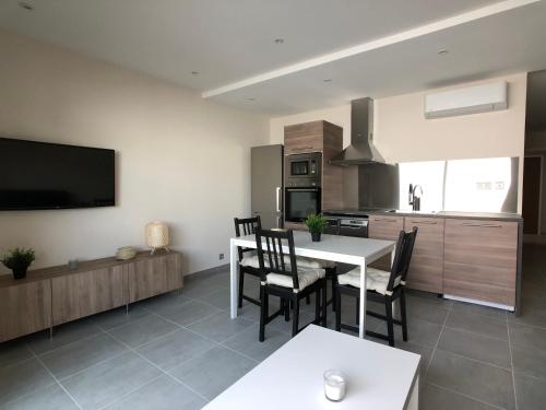 une cuisine et une salle à manger avec une table et des chaises dans l'établissement SCI LA VIEILLE, au Lavandou