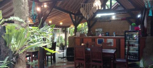 a restaurant with a table and chairs and a bar at Jembrana Bali Homestay in Pengambengan