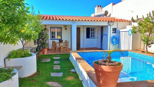 a house with a swimming pool in front of it at Vila Saraz in Campinho