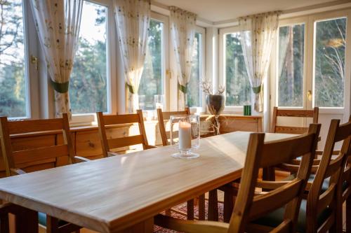 una sala da pranzo con tavolo, sedie e finestre di Haus Schrammsteinblick a Ostrau