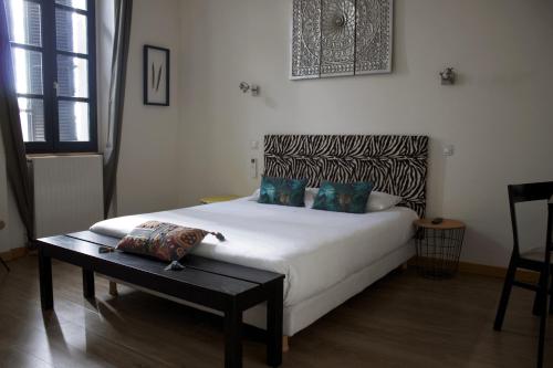 ein Schlafzimmer mit einem weißen Bett und einem Tisch in der Unterkunft Hôtel Absolu in Castelsarrasin