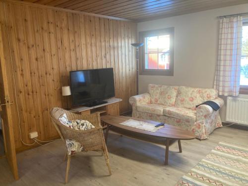 uma sala de estar com um sofá, uma mesa e uma televisão em Furudals Bruk em Furudals Bruk