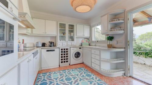 a kitchen with white cabinets and a washer and dryer at Bella Amore Campanet in Campanet