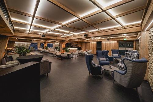 a lobby with a waiting area with chairs and tables at Hotel Meta Resort & Vine SPA in Szczyrk