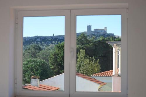 an open window with a view of a building at Casa da Várzea - O Castelo à Janela!!! in Óbidos