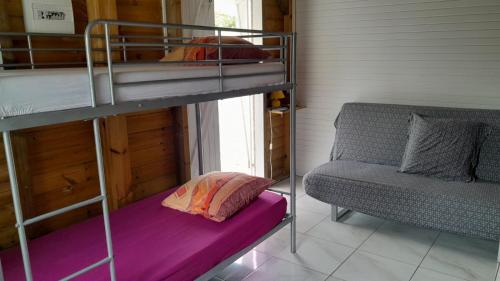 a bunk bed and a couch in a room at Petit chalet vacance in Vidon