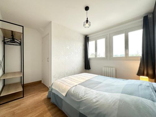 1 dormitorio con cama y espejo en Appartement T3 cosy – Entre bourg et plages, en Ploemeur